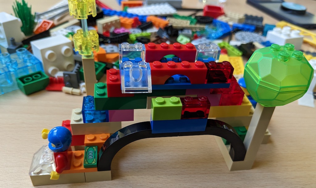 Lego model of a bridge with a minifigure in racing helmet.